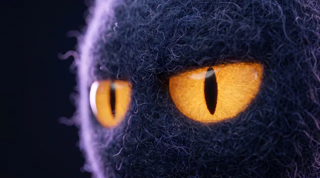 A macro photograph of Monty’s glowing amber eye in dark felt